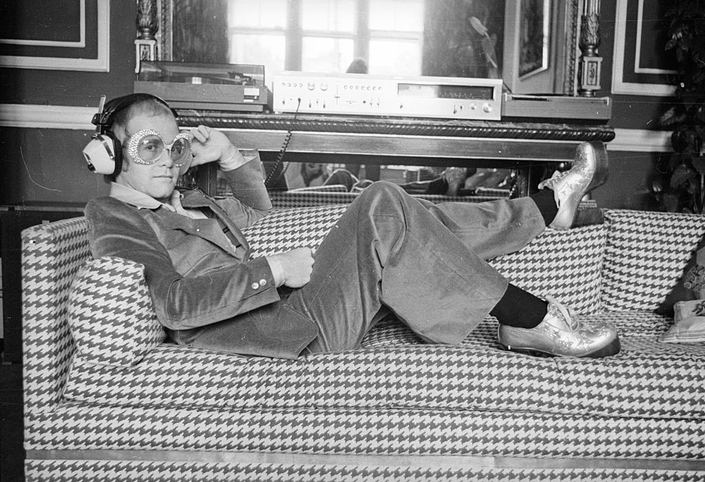 Elton John relaxing on a sofa in September 1974