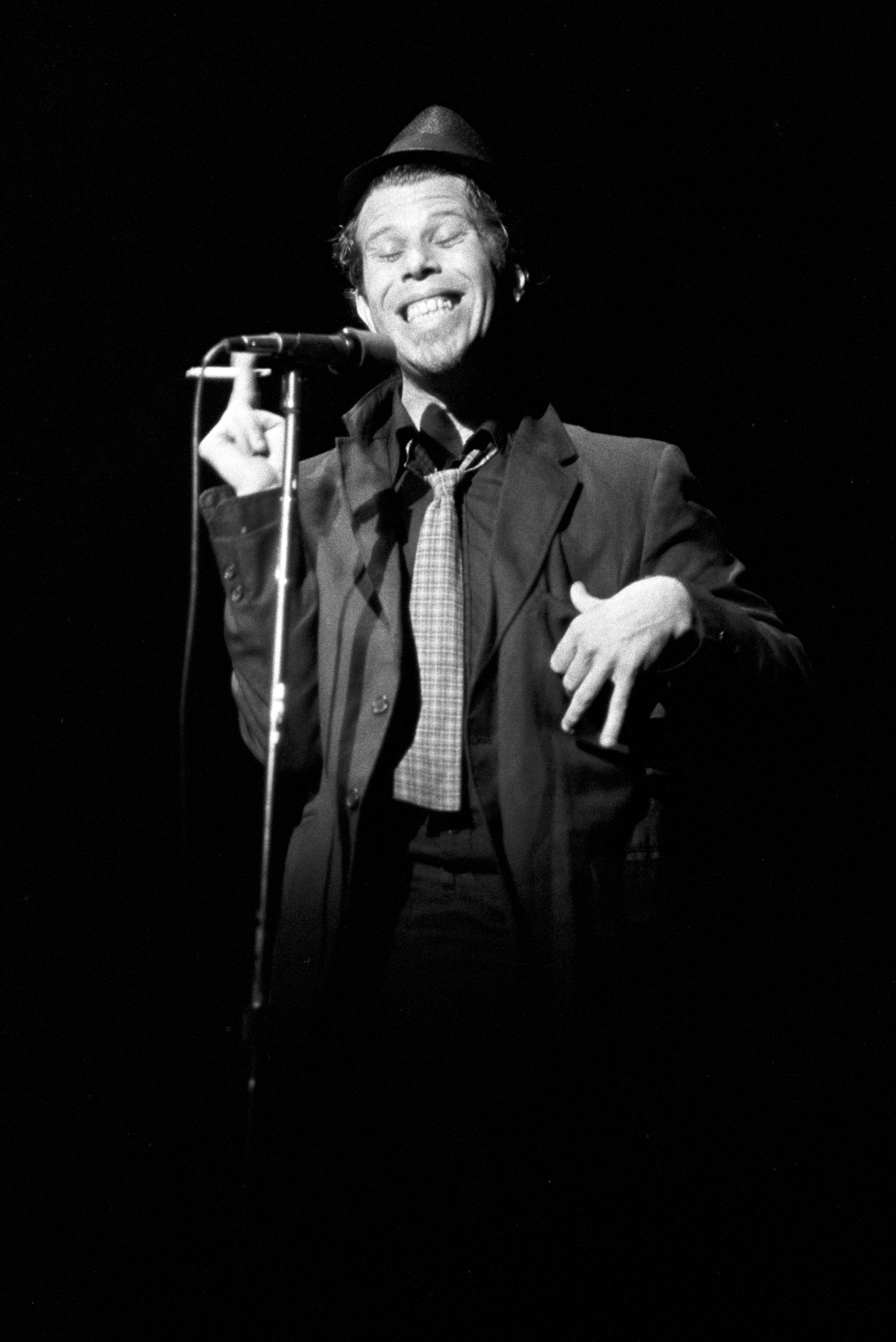 Tom Waits: Our 1985 Interview, <i></noscript>
<p><b>How do you audition a road manager?</b><br />
Well, you take a couple of candidates out toe the Mojave Desert and you leave the car by the side of the road and you walk for a couple of days, and when you get to a stream, the guys that want to drink from a cup, those are the guys you don’t want. It’s the guys that throw themselves headlong into the stream and just drink, those are the best soldiers. What I’m really looking for, though, is an all-midget orchestra. They could all stay in the same room and on stage they could all share the same light.</p>
<p><b>What’s your life like on the road?</b><br />
Well, you get up in the morning, along with millions of other Americans, and you go to the airport. You get to a new town. I go to the Chamber of Commerce as soon as I get in and talk to whoever is in charge. Sometimes I do. But most of the time you really don’t know where you are. It’s very possible that you may come out on stage and say, “It’s great to be here in St. Louis” and you could very well be in Denver or Settle. That’s happened.</p>
<p><b>I really hate it when bands come out and say “Hello, New York.”</b><br />
It’s an arrogant remark, isn’t it? Assuming that everyone of value connected with New York is there. I think it should be against the law for anyone to name a band after a city. <a href=