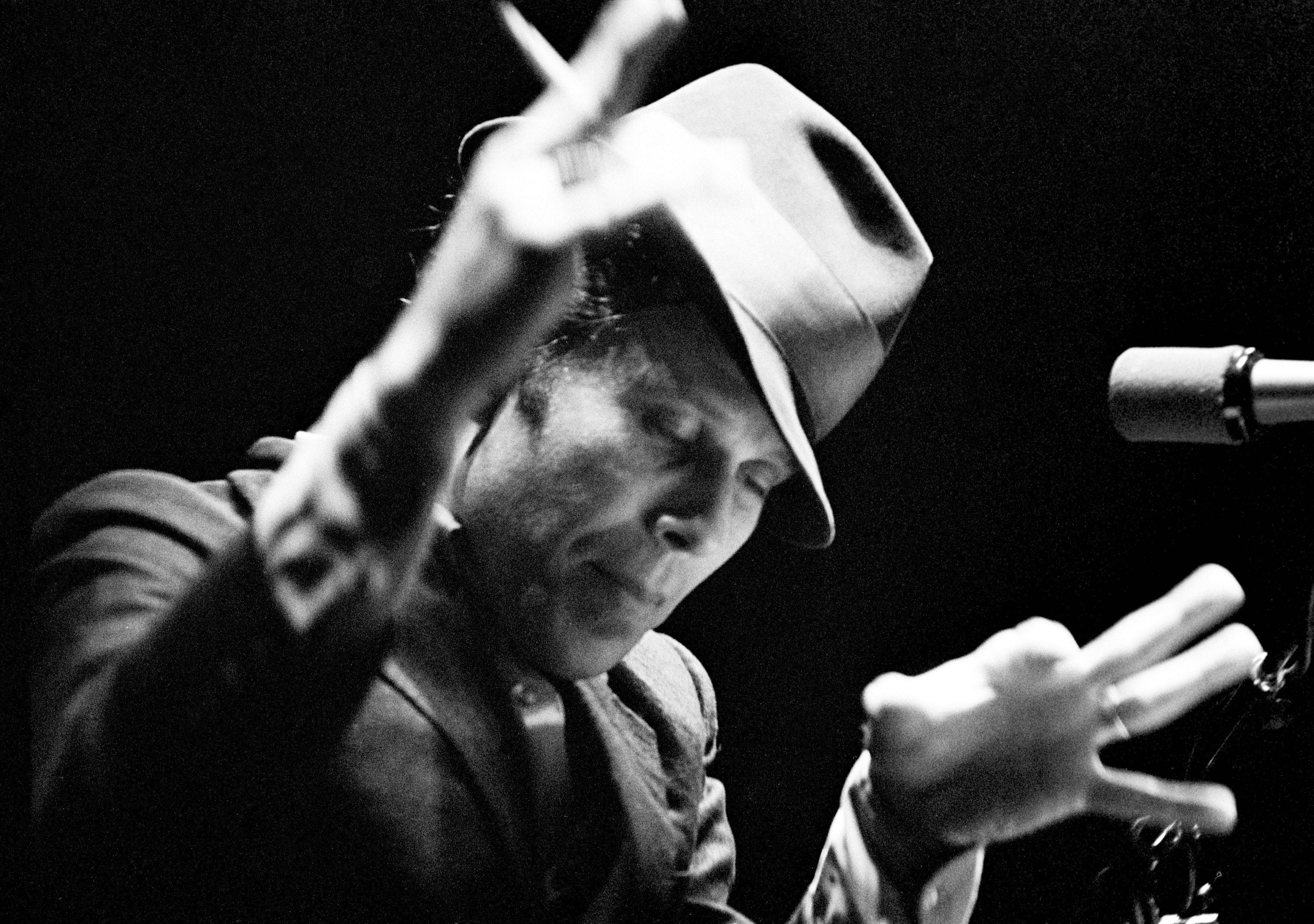 Tom Waits: Our 1985 Interview, <i></noscript>
<p><b>So, what’s your day like?</b><br />
Well, lately it’s been a little easier. I get up at about 7 o’clock with the baby and I get the Rice Krispies going and the french toast, then I put on Mr. Rogers.</p>
<p><b>How old is the baby?</b><br />
Two.</p>
<p><b>Does the baby watch Mr. Rogers or do you?</b><br />
I watch it and I make her watch it with me. I do subtitles. I do a Fourteenth Street version of <i>Mr. Rogers’ Neighborhood</i> where everybody’s out of work and selling drugs on the corner. When I was a kid the show was Sheriff John. He was a policeman. That’s who I was forced to get to know.</p>
<p><b>In New York we had Office Joe Bolton, an Irish cop; he was the host of the Three Stooges show, which, I guess, was supposed to keep a lid on the knucklehead behavior. What’s you baby’s name?</b><br />
Well, we haven’t picked a name yet. I told her that when she’s 18 she can pick any name she wants. In the meantime, we’ll call her something different every day.</p>
<p><b>What is she today?</b><br />
Max today. She’s been everything. We just can’t seem to make up our minds. When she meets somebody and likes them she takes their name. She speaks 17 languages . She’s now in military school in Connecticut. I only get to see her on weekends. At night when I get home all the kids line up in their uniforms and Joe Bob’s got my martini and Max has my slippers and Roosevel has my pipe. They all said “Hello, Daddy!”</p>
<p><b>So what happens after Mr. Rogers?</b><br />
Well, I usually go to sleep under the table somewhere. Every day is different. I go over to the seminary on Tenth Avenue a lot. For a couple of hours. Just to relax. It reminds me of Illinois. I’ve been doing the record for months, so I just got a break. I was getting two or three hours of sleep every couple of months.</p>
<p><b>Did you record in the daytime?</b><br />
Yeah, from about 10 in the morning. I was working in midtown. I had to fight all the traffic and all the other commuters. the hardest thing was just getting to the studio. After that I was alright.</p>
<p><b>This album has really a lot of songs on it.</b><br />
Nineteen. Everybody says that’s too many.</p>
<p><b>Did you record others that didn’t make it on the record?</b><br />
Yeah, I did about 25 all together. There’s a religious song that didn’t get on the album. It’s called “Bethlehem, Pa.” it’s about a guy named Bob Christ. There were a couple of others.</p>
<p><b>What happens to those?</b><br />
They’re orphans. They’re on their own.</p>
<p><b>I’m really interested in the songs that don’t make it onto albums.</b><br />
I end up dismantling them. It’s just like having a car that doesn’t run. You just use it for parts. “The rest of the guys are gonna have to go out there now and bring Dad home some money. So all of you guys go out there and stick together. Bob, you look out for your younger brother there. And all of you go out there into the world of radio and performance value.” I feel like Fagin.</p>
<p>It took a long time to record this album, two and a half months. The recording process has a peak, and then it dissipates. You have to be careful that it doesn’t go on too long. Then you start to unravel everything.</p>
<p>Nowadays, if you want a certain sound you don’t have to get it now, you can get it later. When you’re mixing, electronically. I wanted to get it now, so I feel like I cooked it and I ate it. You can establish percussion sounds later electronically. But I ended up banging on things so I felt that it really responded. If I couldn’t get the right sound out of the drum set we’d get a chest of drawers in the bathroom and hit it real hard with a two-by-four. Things like that. That’s on “Singapore.” Those little things made me feel more involved than sampling on a synthesizer.</p>
<img src=