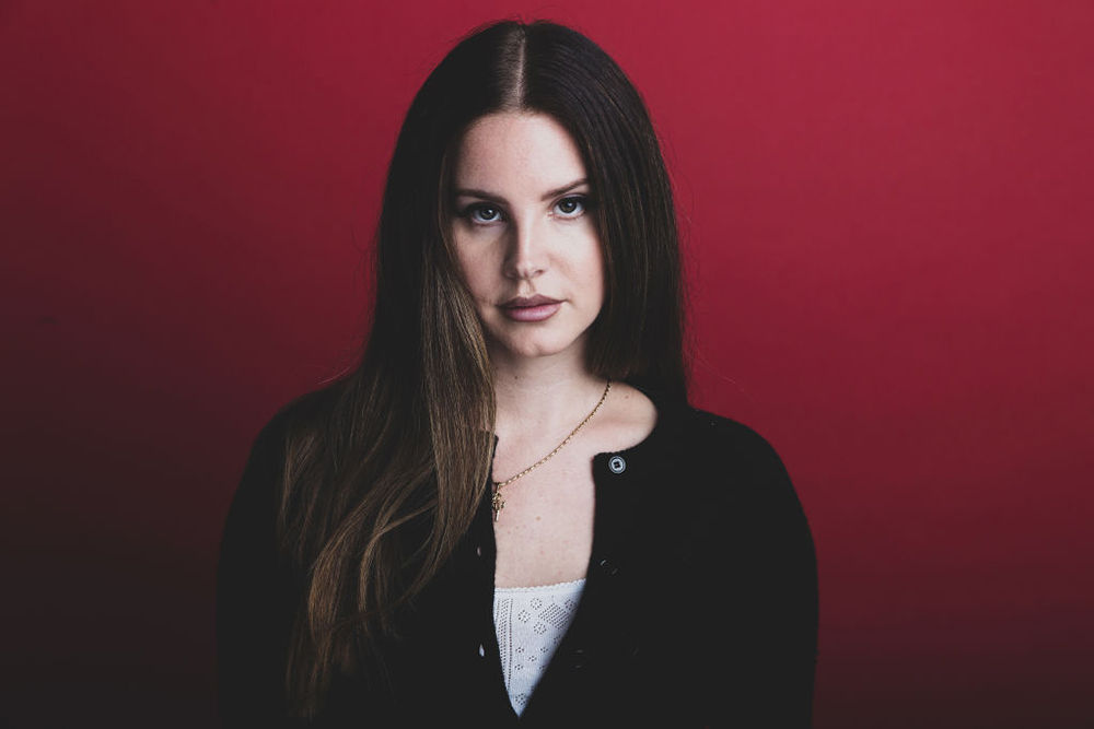Lana Del Rey in front of red background