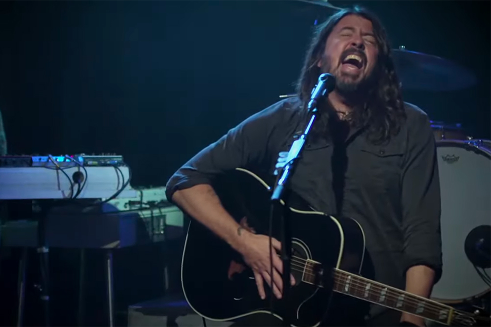 dave grohl of foo fighters singing and holding guitar