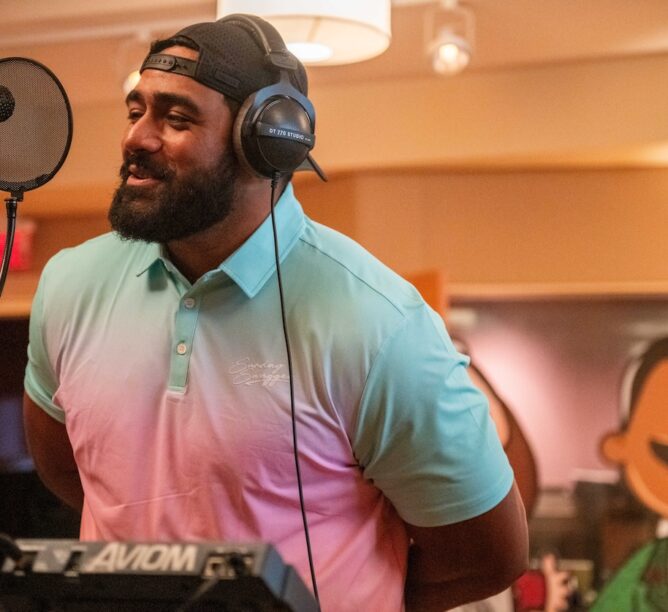 Philadelphia Eagles offensive tackle Jordan Mailata sings into the microphone for the new Philly Specials Christmas album. (Credit: Kait Pritivera)