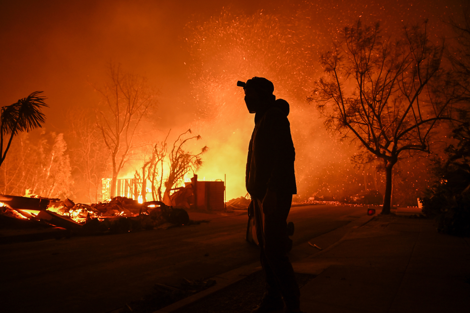 A house is on fire as residents try to escape the site in Pacific Palisades, January 8, 2025. (Credit: Tayfun Coskun/Anadolu via Getty Images)