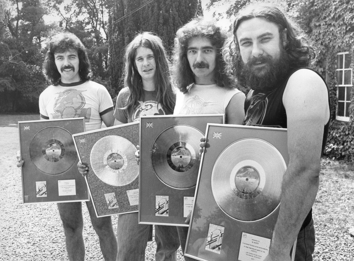 Tony Iommi, Ozzy Osbourne, Geezer Butler and Bill Ward of Black Sabbath pwith the silver discs they received for the album 'Technical Ecstasy' in 1977. (Credit: Birmingham Post and Mail Archive/Mirrorpix/Mirrorpix via Getty Images)
