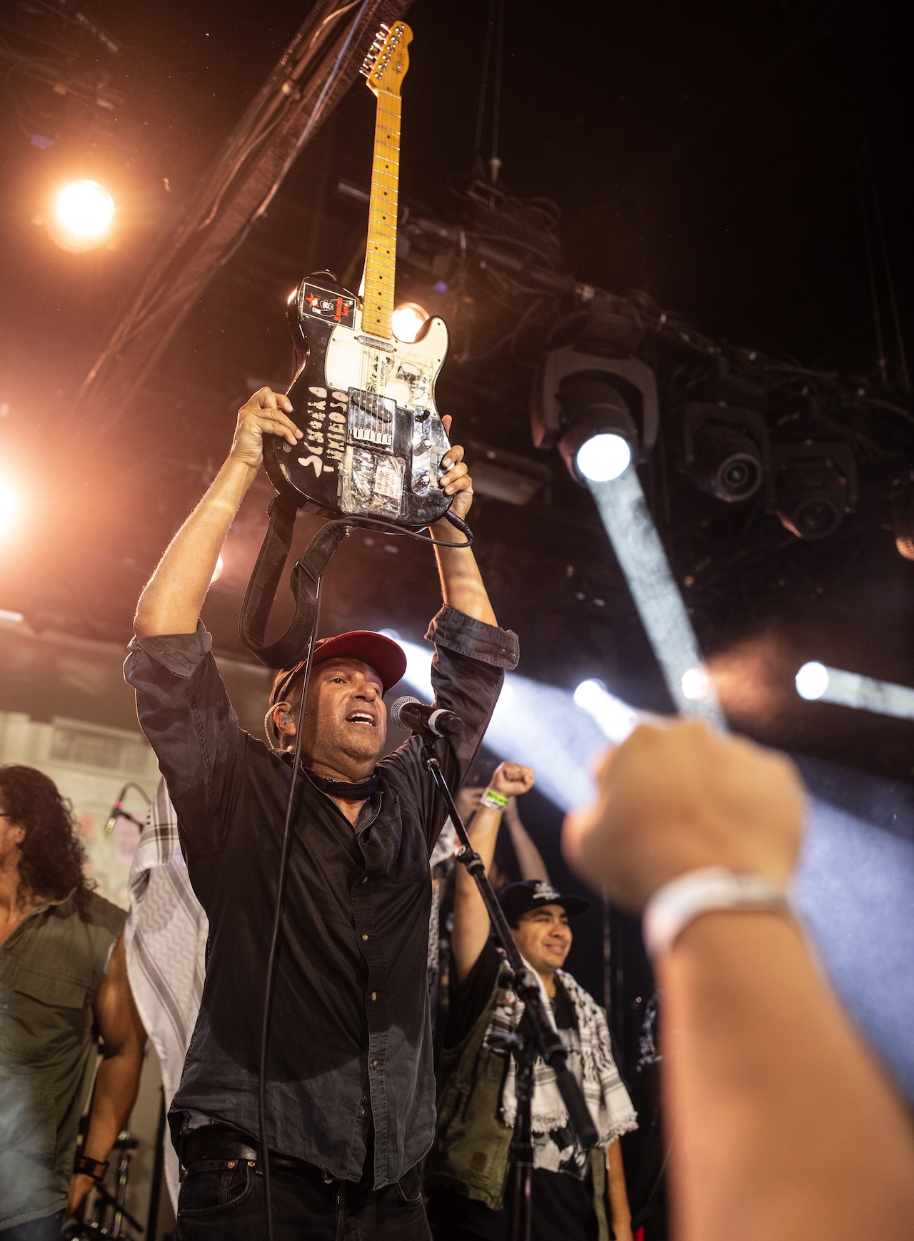 Tom Morello hold his guitar in triumph at his "Defend L.A." fundraiser.