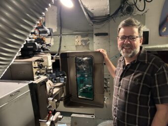 Matt Cunningham, technical director and head projectionist, shows off projector capable of displaying 35mm and 70mm movies. (Credit: David Harris)