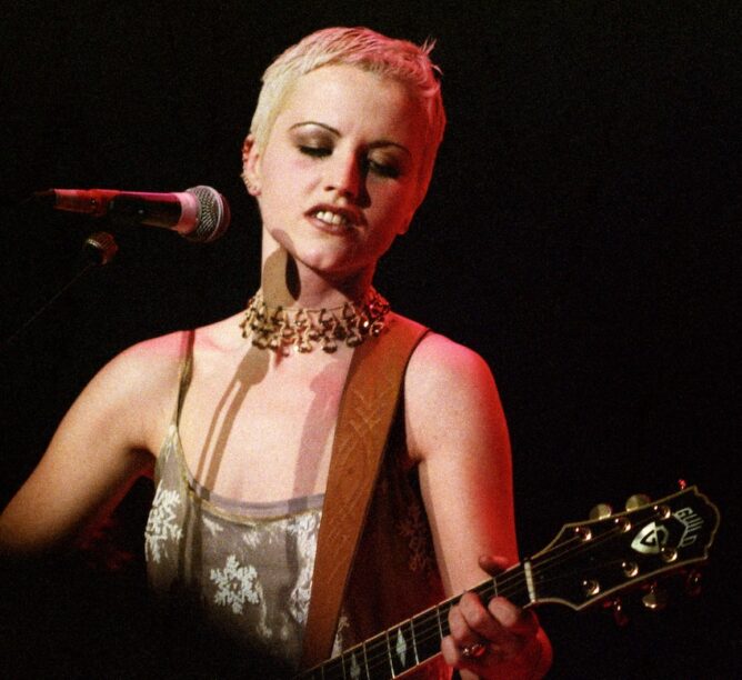 Singer and guitarist Dolores O'Riordan of the Cranberries performs on stage in 1995. (Credit: Pete Still/Redferns)