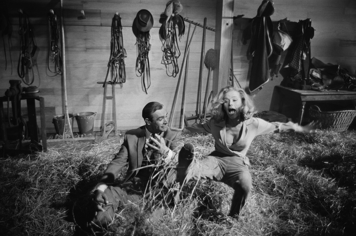 Honor Blackman as Pussy Galore and Sean Connery as James Bond rehearsing stunts scenes in a barn on the set of Goldfinger in 1964. (Credit: Larry Ellis/Daily Express/Hulton Archive/Getty Images)