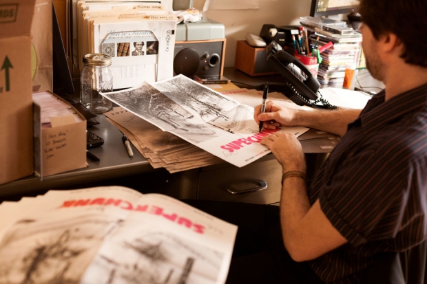 Wurster signs posters for the band's new record at the MERGE Records office. / Photo by Jeremy M. Lange